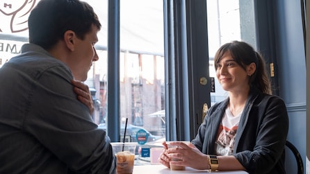 Lizzy Caplan as Libby Epstein having coffee with Jesse Eisenberg as Toby Fleishman in cafe in FX's Fleishman Is In Trouble