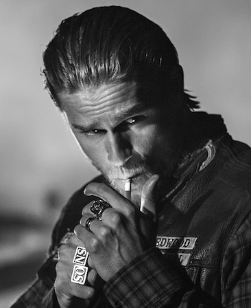 Charlie Hunnam headshot lighting a cigarette in his mouth 