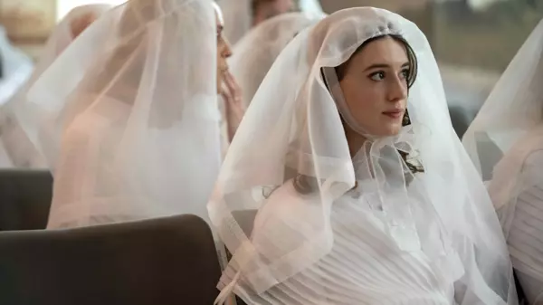 A woman sitting in a white wedding dress and veil