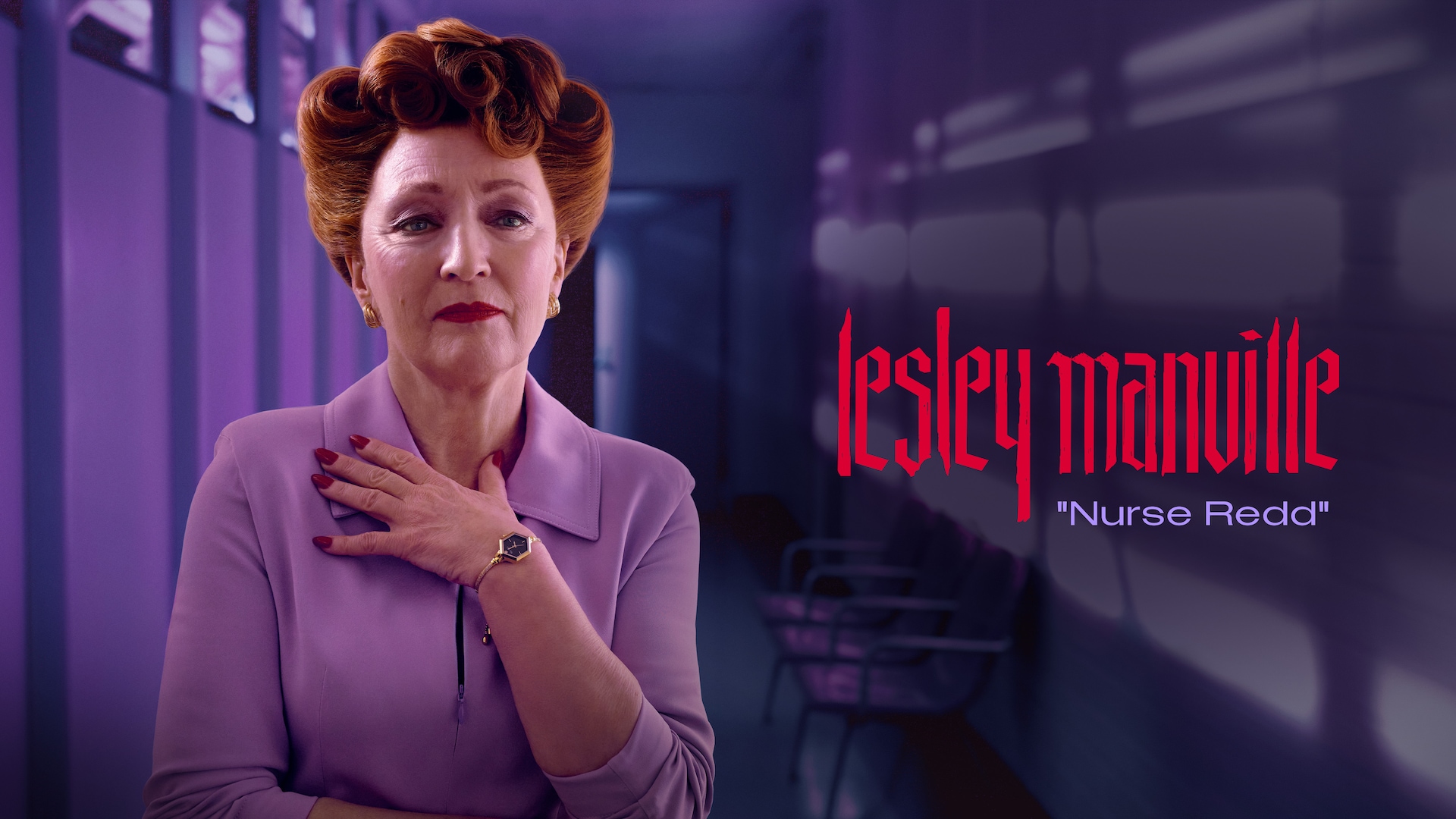 Lesley Manville as Nurse Redd in FX's Grotesquerie with her hair in an updo, wearing red lipstick in a purple coat.