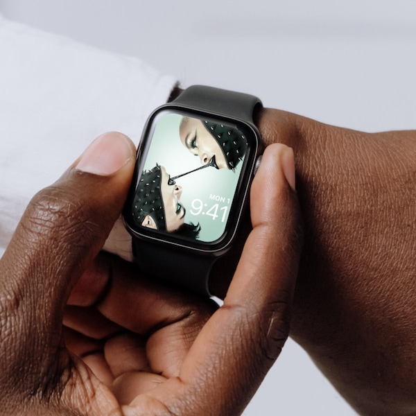 Man wearing Apple Watch with lock screen of two blue eyed people with black metal chain from their mouths from FX's AHS NYC