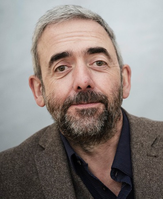 Simon Blackwell headshot in wool blazer with navy button down and light grey background