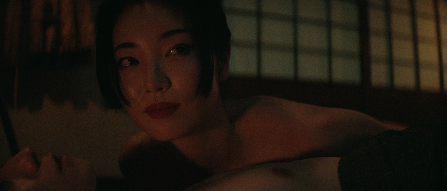 Courtesan Kiku smiles as she lays atop Yabushige's kosho
