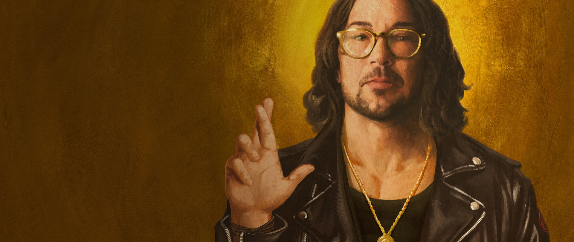 Pastor Carl Lentz with long wavy hair in a black leather jacket and gold chain with right hand raised with fingers crossed.