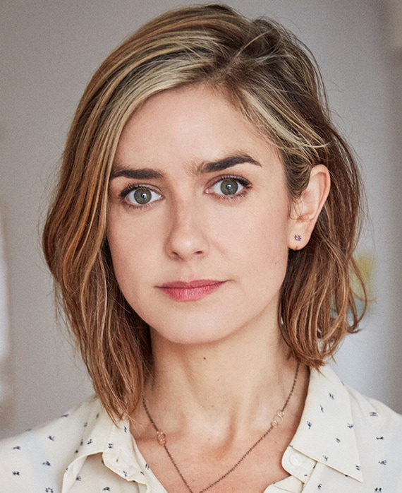 Headshot of Gina Welch wearing a white patterned button up.