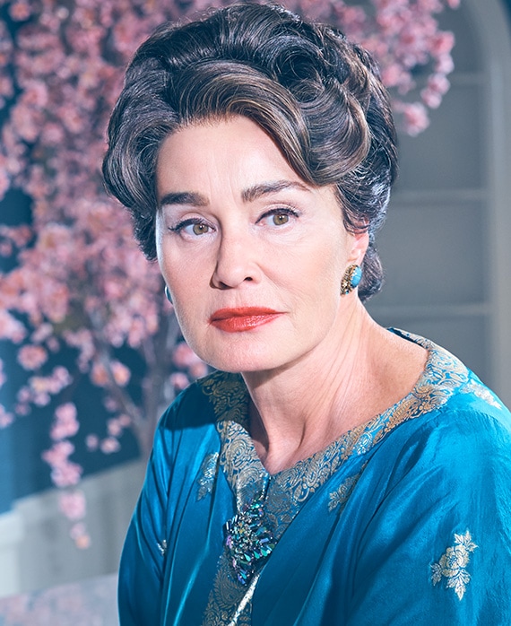 Jessica Lange as Joan Crawford wearing blue gown and blue earrings and cherry blossoms in background in Feud FX show