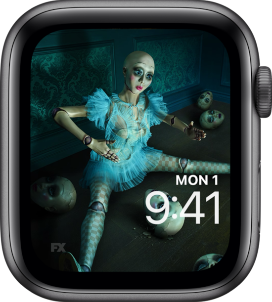 Apple Watch lock screen of doll sitting with doll heads and wearing blue dress FX's American Horror Stories