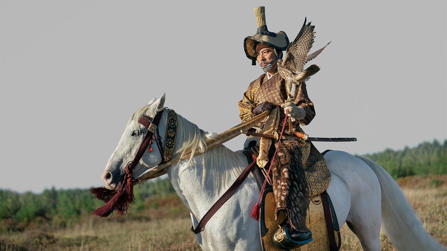 Toranaga riding a white horse holding a falcon