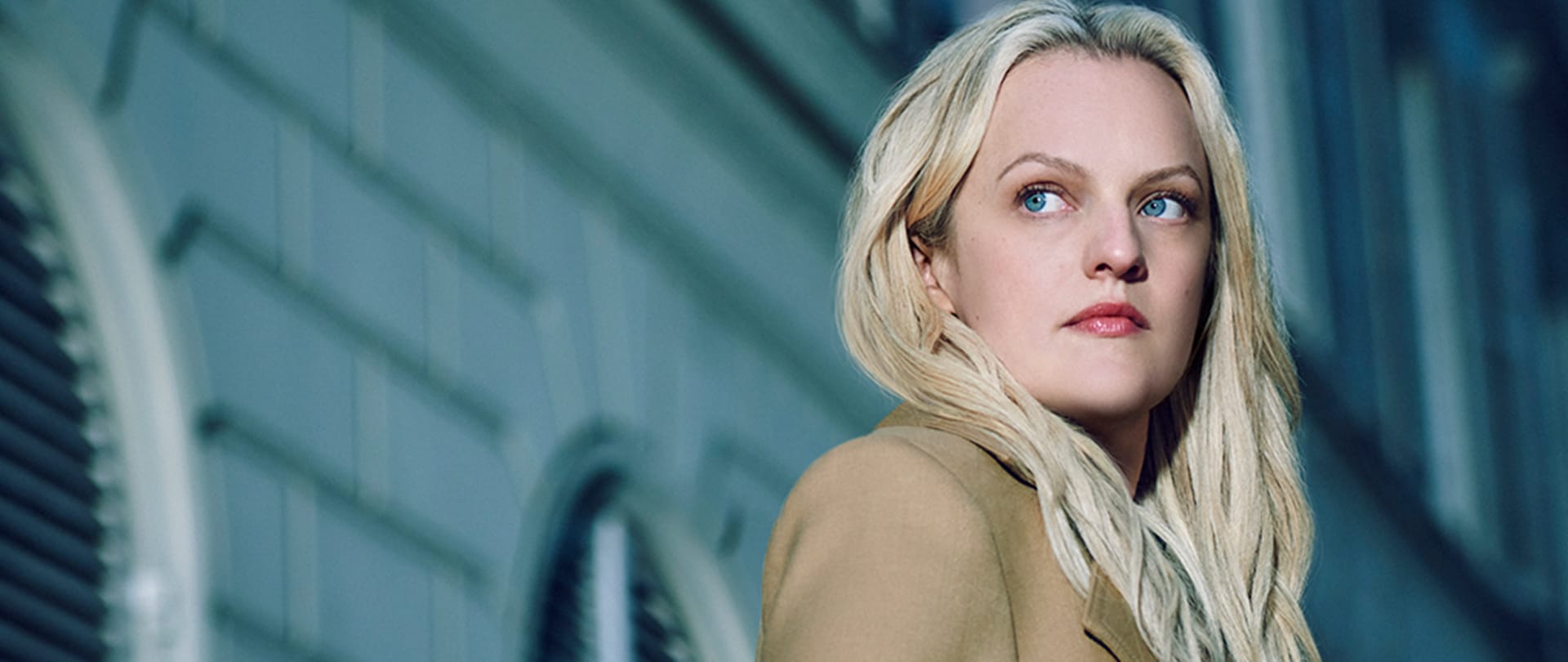 Elisabeth Moss as Imogen Salter in FX's The Veil, standing to the side of a building.