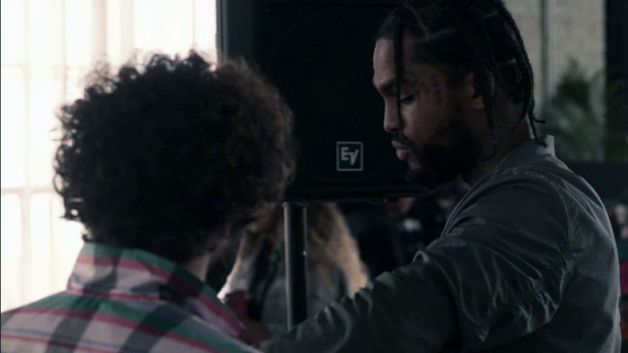 Dave wearing plaid shirt talking to Dave East looking down from Dave FX show