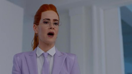 Sarah Paulson as Ms Wilhemina Venable in purple suit and tie with red hair in ponytail in white room in AHS Apocalypse