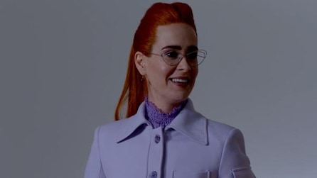 Sarah Paulson as Ms Wilhemina Venable in purple coat and turtleneck smiling in American Horror Story Apocalypse 