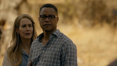 Sarah Paulson wearing denim top and Cuba Gooding Jr in glasses and blue plaid shirt outside in yellow field in AHS Roanoke