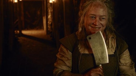Kathy Bates bloodied and holding butcher knife onto her chin while grinning in dark alleyway in AHS Roanoke