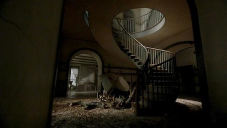 Tall spiral staircase in abandoned house with broken furniture at beginning of the stairs in AHS Roanoke