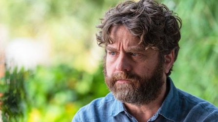 Zach Galifianakis in denim collared shirt outside with bright greenery in background in FX's Baskets