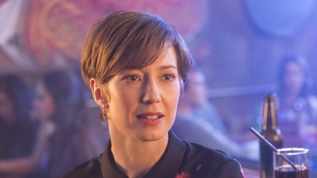 Carrie Coon as Gloria Burgle with short brown hair inside bar with iridescent purple lighting in FX's Fargo Year Three