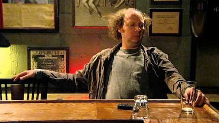 Dan Bakkedahl as Steve sitting at bar top with empty glasses in FX's Legit