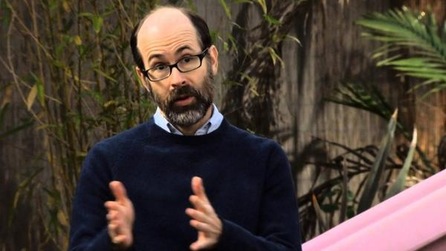 Man with beard and glasses holding out hands with pink object in background against wooden fence in FX's Legit