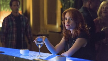 Woman sitting at a bar holding a drink