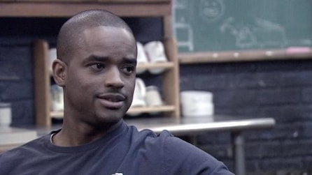 Headshot of Black Shawn wearing a navy tshirt, turned to the side with chalk board in background from FX's Rescue Me