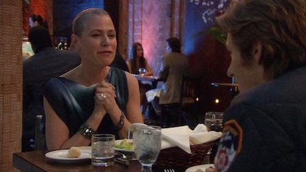 A couple clasping her hand while at a dinner table