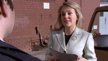 Woman wearing a gray suit holding papers