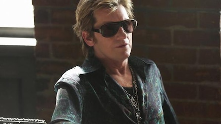 Man wearing dark sunglasses and silver necklaces