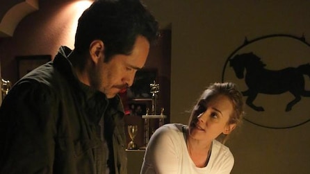 Diane Kruger as Sonya talking to Demian Bichir as Marco in room with trophies and horse painting on wall in FX's The Bridge