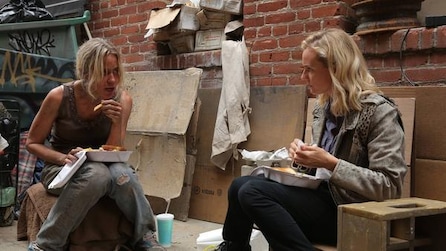 Diane Kruger as Sonya sitting down outside house eating lunch with haggard blonde woman in FX's The Bridge