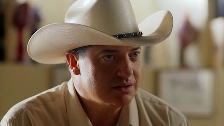 A man in a large cowboy hat and collar shirt