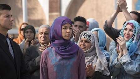 Multiple women in a crowd wearing head scarfs 