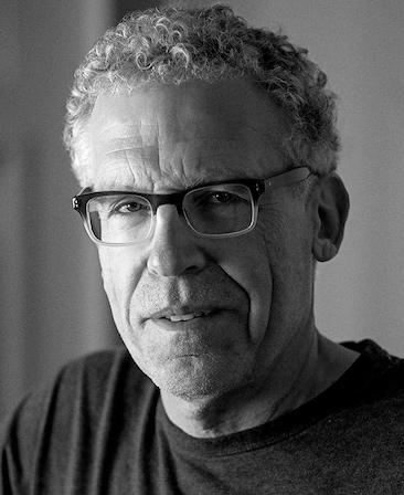 Carlton Cuse Headshot wearing glasses with a black and white filter