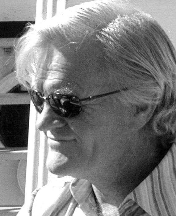 David Weddle Headshot wearing sunglasses and smiling with a black and white filter