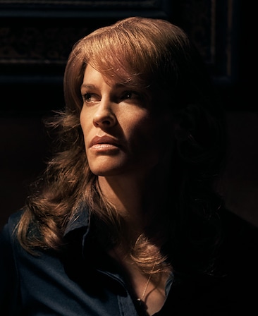 Hilary Swank Headshot wearing a blouse in dark lighting