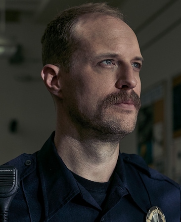 Adam David Thompson Headshot wearing a police uniform