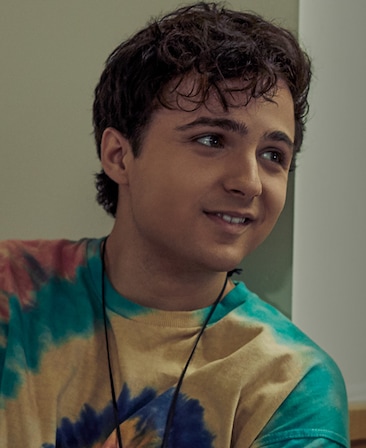 Dylan Schmid Headshot wearing a tie dye shirt and necklace
