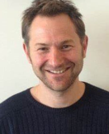 Danny Brocklehurst Headshot smiling and wearing a black shirt