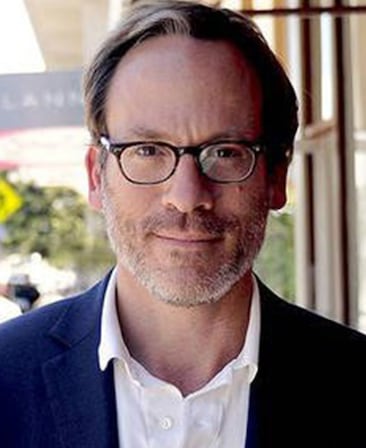 Michael Costigan Headshot wearing a white button down and glasses