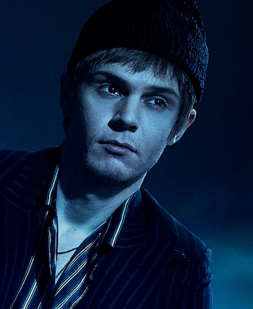 Headshot of Evan Peters in striped suit and short brown hair in beanie from FX's American Horror Story Double Feature
