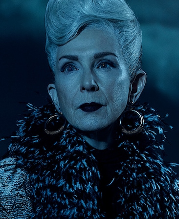 Headshot of Frances Conroy with styled white hair in fur jacket and gold hoops from FX's AHS Double Feature
