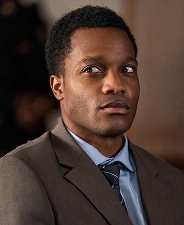 Jermaine Fowler headshot wearing a blue shirt and navy time with a gray suit jacket