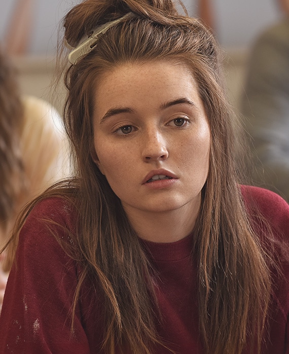 Kaitlyn Dever headshot wearing a red sweater and clip in her hair