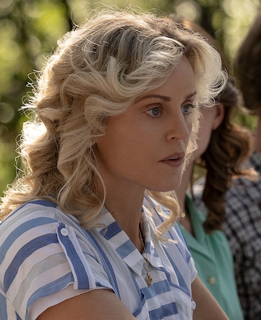 Denise Gough headshot wearing a blue and white striped shirt standing outside
