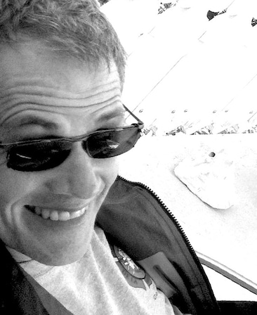 Bradley Thompson Headshot smiling and wearing sunglasses with a black and white filter