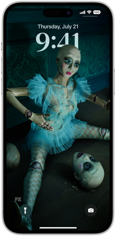 iPhone lock screen of doll on floor wearing blue dress surrounded by doll heads from FX's American Horror Stories
