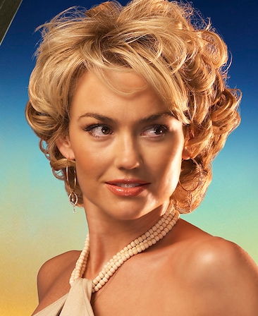 Kelly Carlson headshot wearing a white top with white beaded neckline