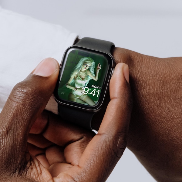 Man wearing Apple Watch with lock screen of doll in lingerie and veil and holding needle in FX's American Horror Stories