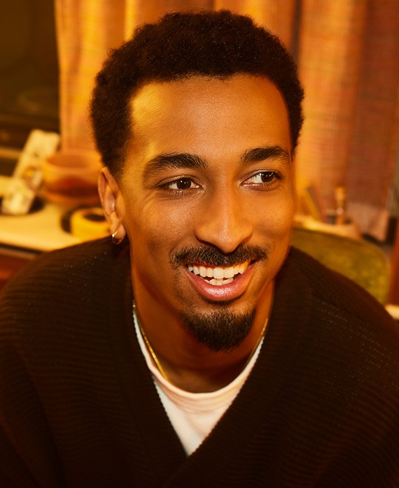 Travis Bennett smiling while wearing a black sweater over a white shirt