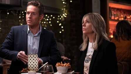 Dennis and Dee standing inside a dark restaurant.